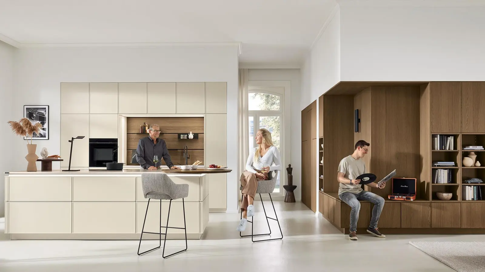 Modern und gemütlich wirkt diese grifflose Küchen- und Wohnlandschaft mit ihrem minimalistisch-klaren Design und den feinen, schmalen Rahmenfronten. Der von der Natur inspirierte zarte Farbton erinnert an helle Muscheln und harmoniert ausgezeichnet mit den dunkleren Eichenholz-Fronten. (Foto: AMK)