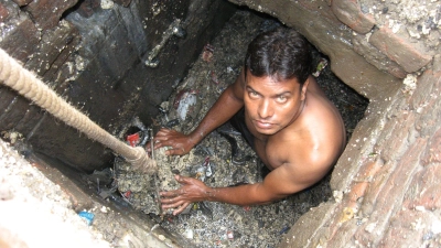 Ein Kanalreiniger arbeitet in einem Außenbezirk von Neu Delhi in der Kanalisation - ohne Schutzkleidung. (Foto: -/Organisation SKA/dpa)