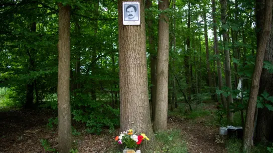 Eine Gedenktafel mit dem Abbild des NSU-Opfers Enver Şimşek hängt 2018 am Tatort in Nürnberg an einem Baum. (Foto: Daniel Karmann/dpa)