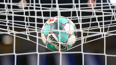 Ein Fußball liegt vor der Partie im Netz. (Foto: Friso Gentsch/dpa/Symbolbild)