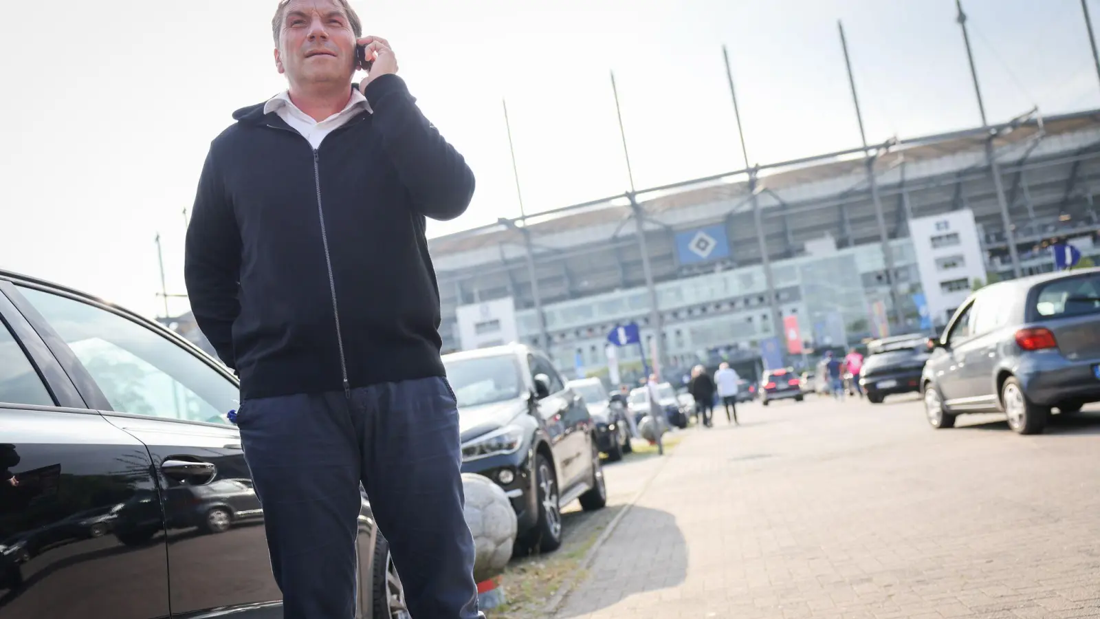 Thomas Wüstefeld, Noch-Vorstand des Hamburger SV, telefoniert vor einem Spiel auf dem Parkplatz vor dem Stadion. (Foto: Christian Charisius/dpa)