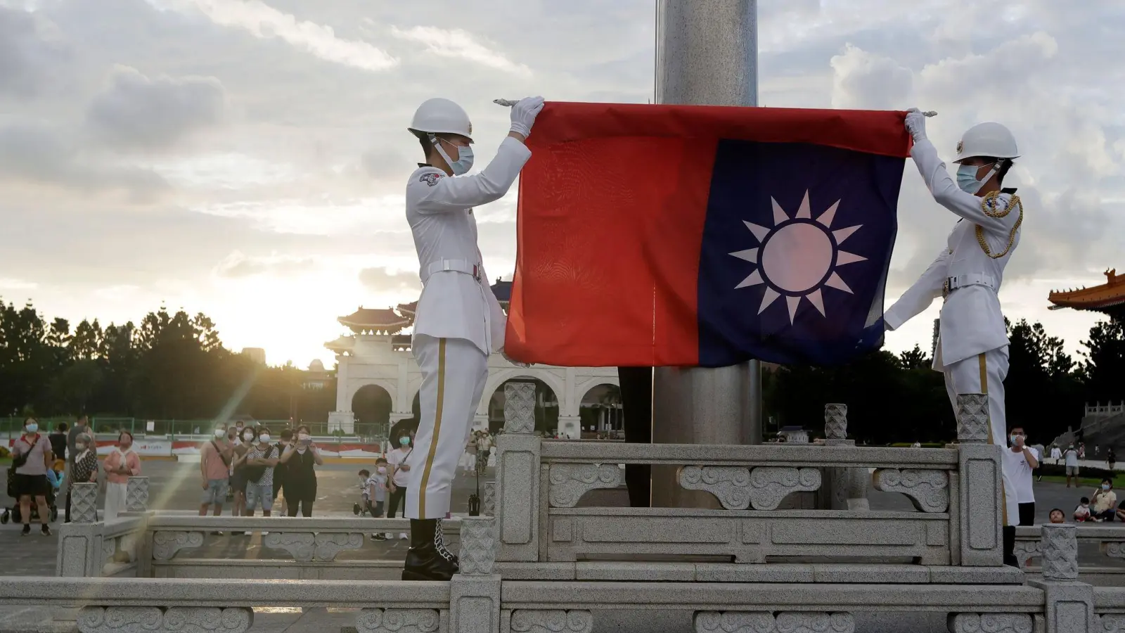 Zwei Soldaten falten die Nationalflagge während der täglichen Flaggenzeremonie auf dem Freiheitsplatz der Chiang-Kai-shek-Gedenkhalle in Taipeh. (Foto: Chiang Ying-Ying/AP/dpa)