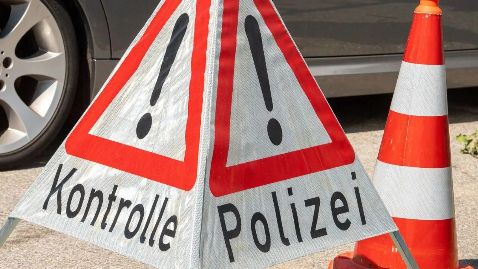 Ein Schild mit Aufschrift „Kontrolle Polizei“ steht auf einem Parkplatz. (Foto: Peter Kneffel/dpa)