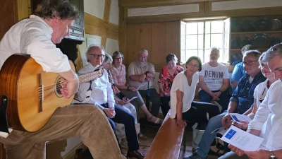 Christoph von Weitzel (links) begleitete sich in der Oberschlauersbacher Mühle auf der Gitarre und interpretierte bekannte Volkslieder. (Foto: Nicole Paskow)