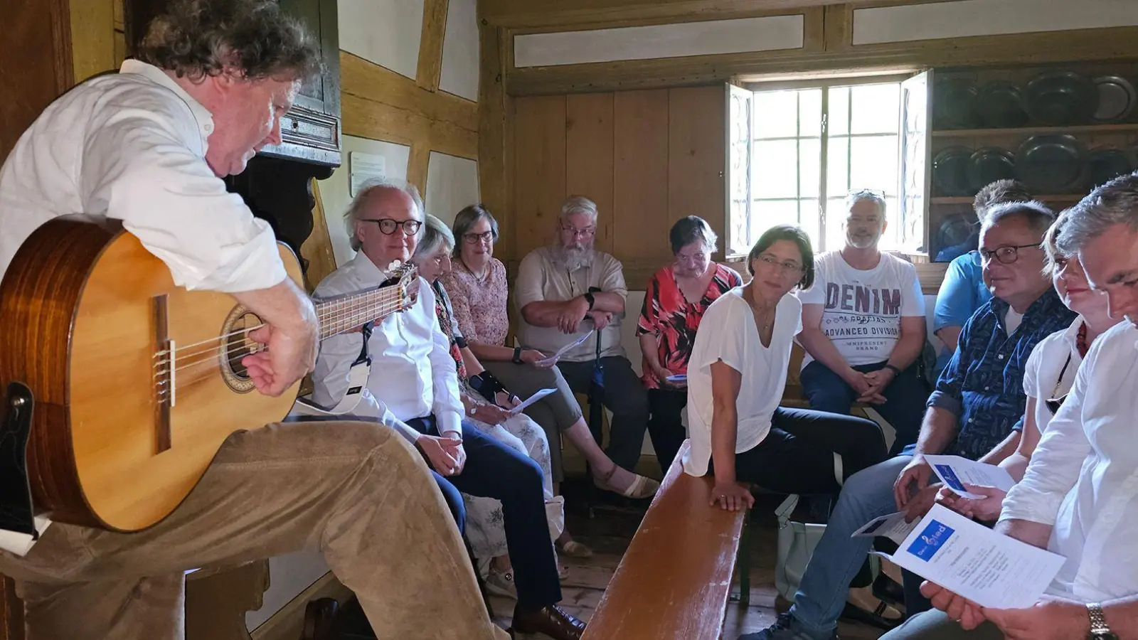 Christoph von Weitzel (links) begleitete sich in der Oberschlauersbacher Mühle auf der Gitarre und interpretierte bekannte Volkslieder. (Foto: Nicole Paskow)
