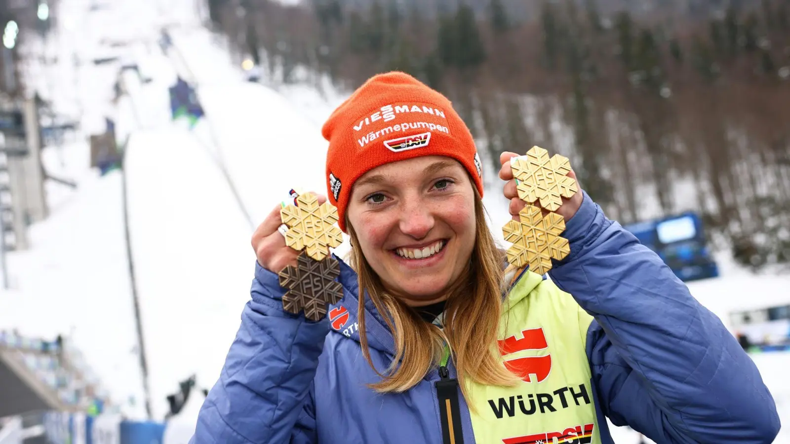 Katharina Schmid aus Deutschland, dreimalige Skisprung-Weltmeisterin von Planica, zeigt ihr Medaillenset, bestehend aus drei Goldmedaillen und einer Bronzemedaille. (Foto: Daniel Karmann/dpa/Archivbild)