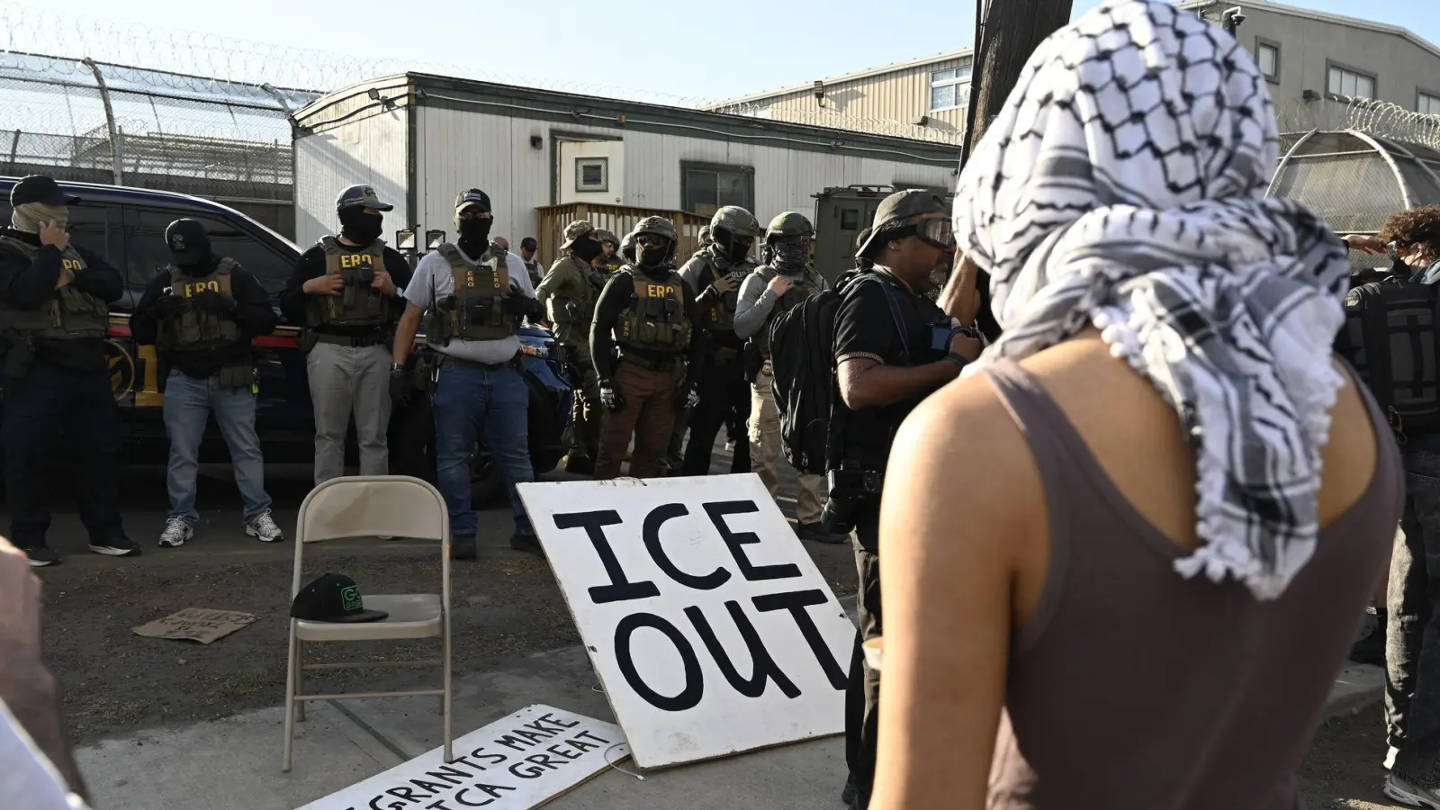 Vor Bundesbeamten der Einwanderungsbehörde ICE haben Demonstrierende ein großes Schild mit der Aufschrift „ICE out“ drapiert. (Foto: Anne Pollmann/dpa)