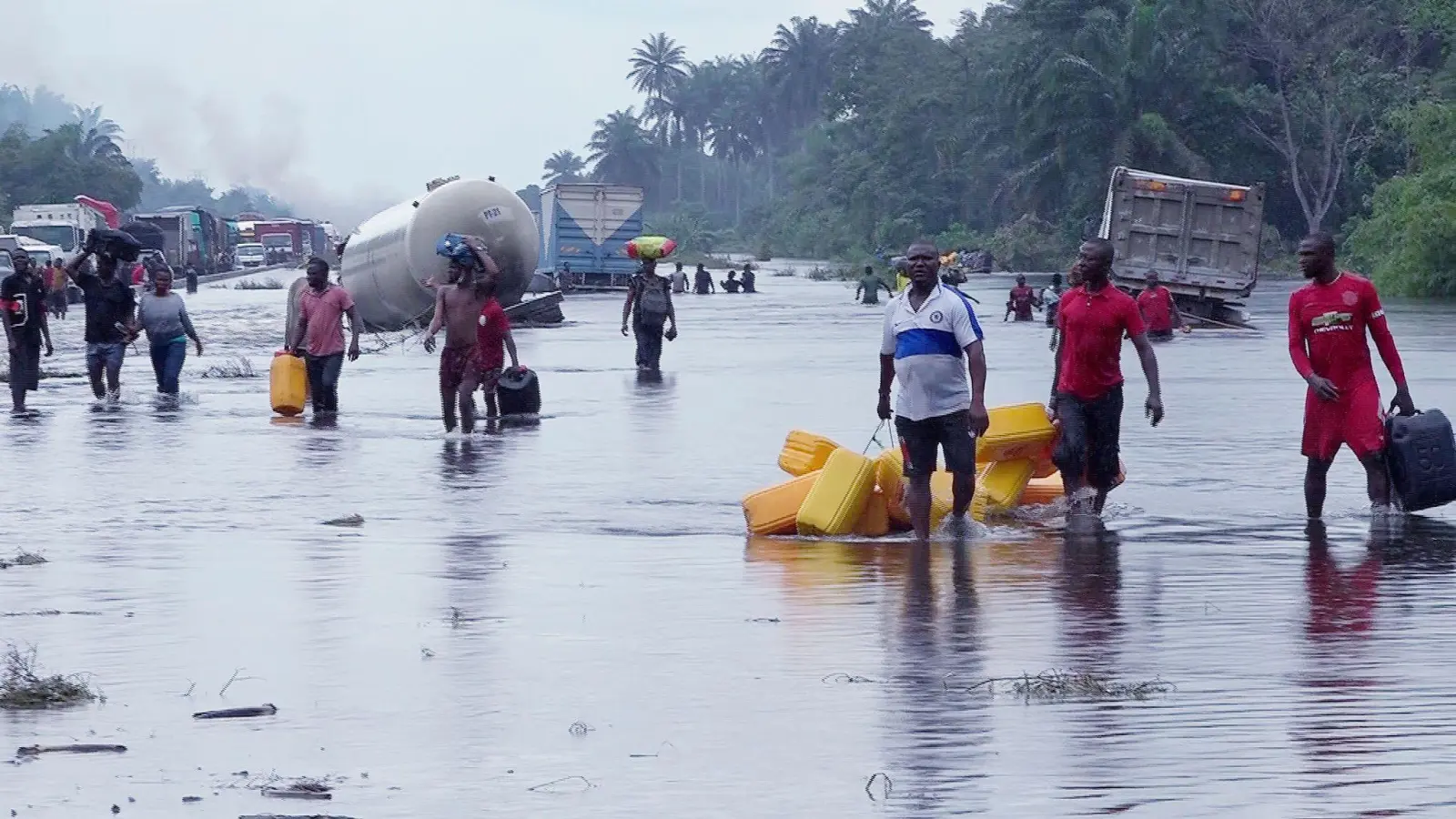 Menschen im nigerianischen Bayelsa waten durch überflutete Straßen. (Foto: Reed Joshua/AP/dpa)