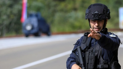 Ein Kosovo-Polizist bewacht eine Straße in der Nähe des Dorfes Banjska. Maskierte Angreifer haben im Norden des Kosovos einen Polizisten erschossen. (Foto: Bojan Slavkovic/AP/dpa)