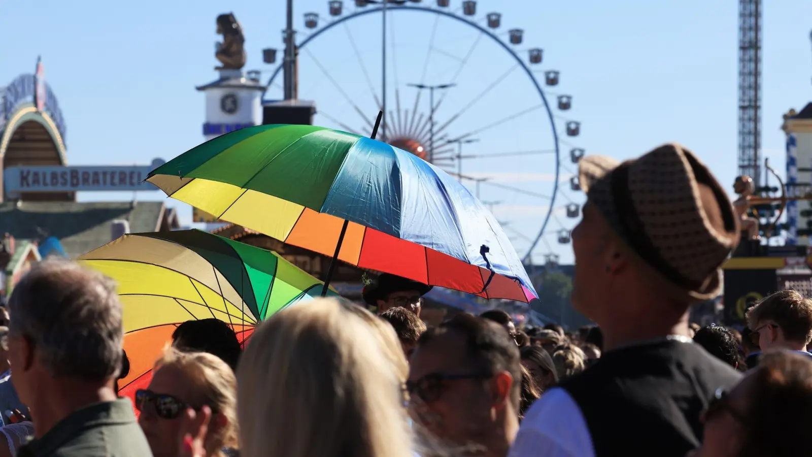 Mit Schirmen schützten sich Oktoberfest-Besucher vor den intensiven Sonnenstrahlen. (Foto: Karl-Josef Hildenbrand/dpa)