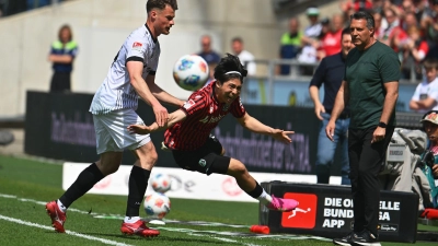 Münsters Verteidiger Niko Koulis (l) foult Hannovers Daisuke Yokota. (Foto: Swen Pförtner/dpa)