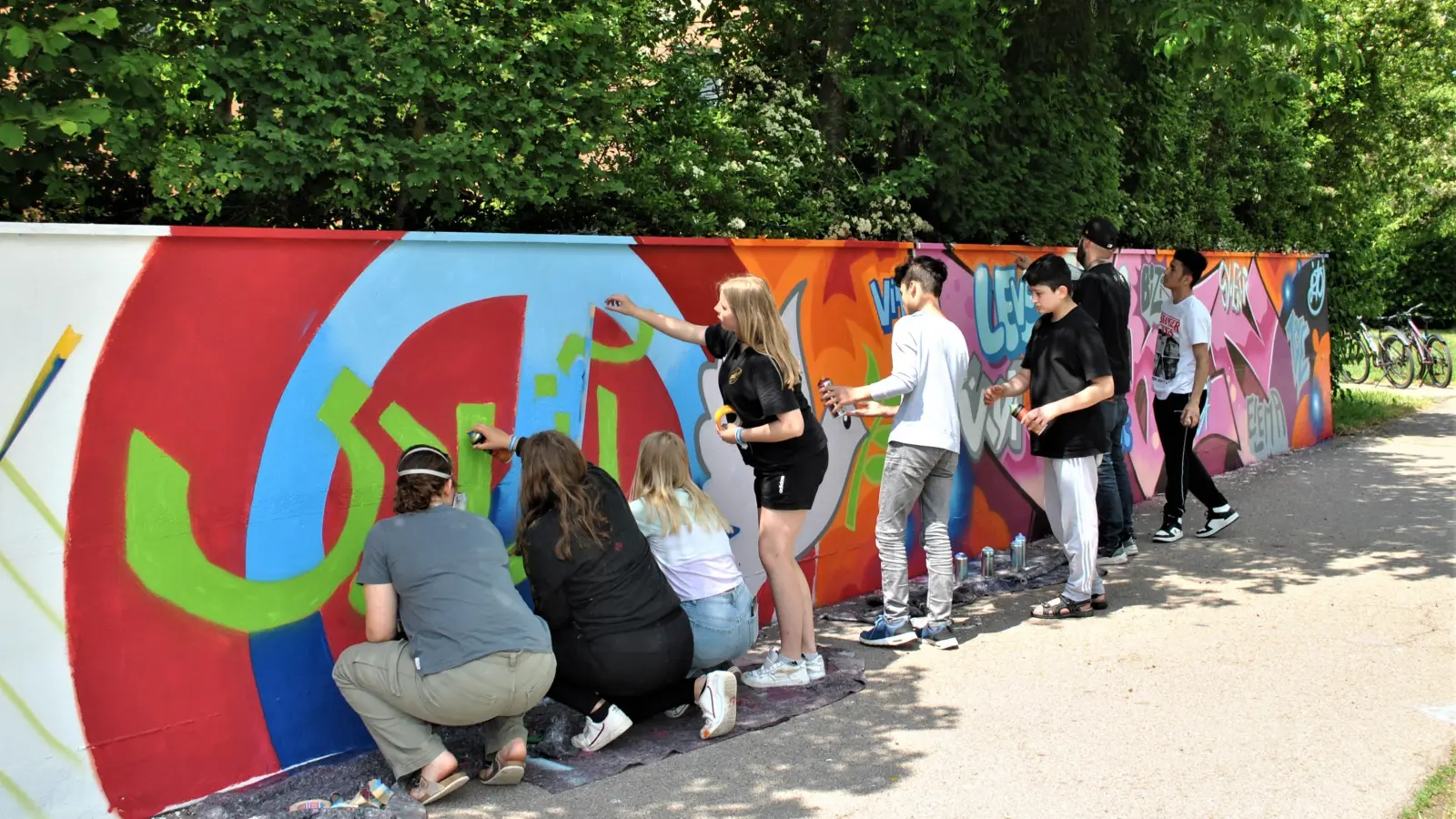 Graffiti-Sprühen im Tandem: Jeweils ein einheimischer und ein geflüchteter Jugendlicher bildeten bei der Aktion ein Team. Fünf Tage lang jeweils fünf Stunden arbeiteten die jungen Leute an ihrem Kunstprojekt. (Foto: Petra Mai)