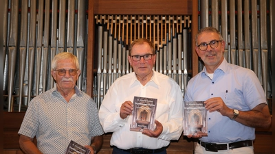 Friedrich Weinberger, Kirchenmusikdirektor Rainer Goede und Dekan Dr. Matthias Büttner präsentieren das neue Werk vor der heutigen Orgel in der Kirche St. Johannis (von links). (Foto: Alexander Biernoth)