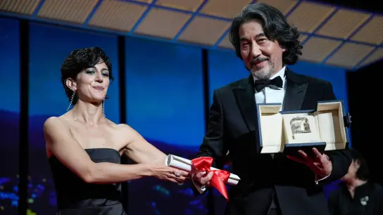 Zahra Amir Ebrahimi (l) überreicht Koji Yakusho den Preis als bester Schauspieler für seine Rolle im Film „Perfect Days“ von Regisseur Wenders. (Foto: Daniel Cole/AP)