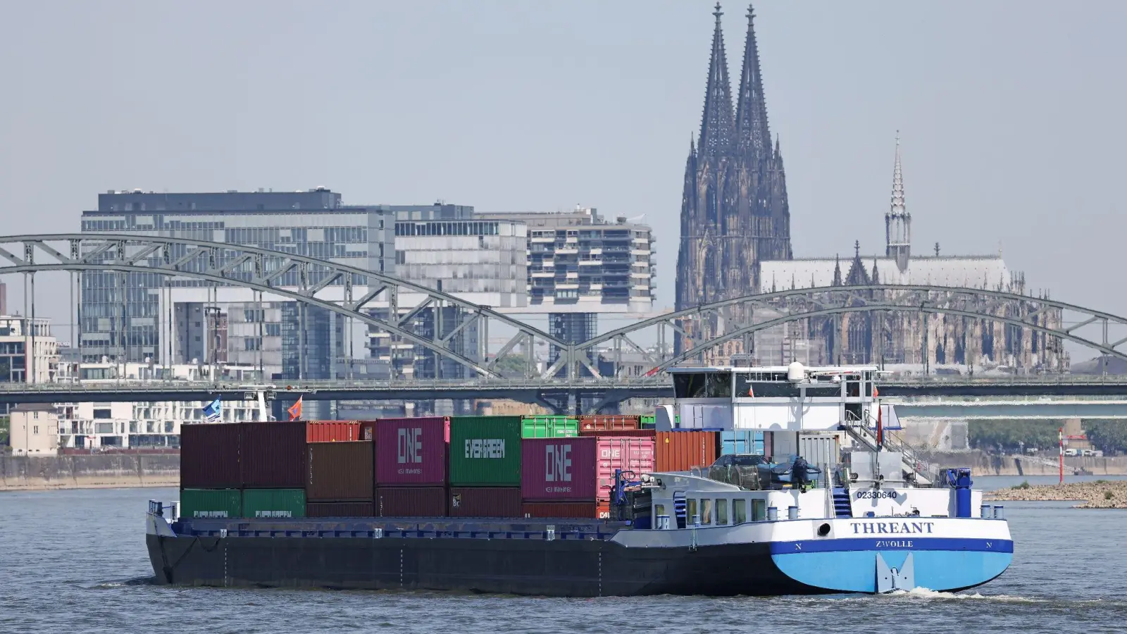 Ein mit Containern beladenes Binnenschiff über dem Rhein. (Foto: Oliver Berg/dpa)