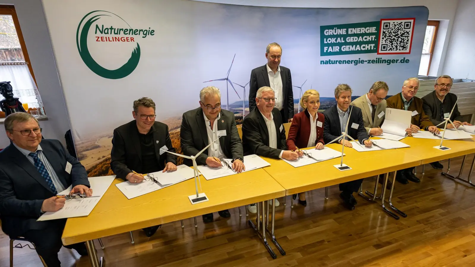 Vertragsunterzeichnung für den Bürgerwindpark Steigerwald: Beim Besuch von Minister und Vize-Ministerpräsident Hubert Aiwanger (hinten, stehend) unterschrieben die Bürgermeister der sechs Kommunen und die weiteren Projektbeteiligten die Unterlagen.  (Foto: Mirko Fryska)