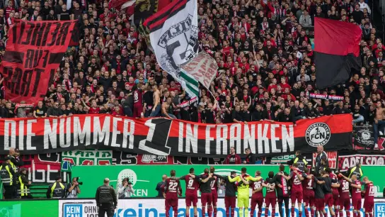 Die Nürnberger Spieler jubeln nach dem Abpfiff über ihren Sieg vor der Fankurve. (Foto: Daniel Karmann/dpa/Archivbild)