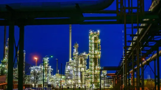 Die Anlagen der Erdölraffinerie auf dem Industriegelände der PCK-Raffinerie GmbH sind abends beleuchtet. (Foto: Patrick Pleul/dpa)