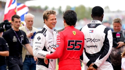 Brad Pitt (l, im Gespräch mit Fahrer Carlos Sainz) und Damson Idris (r) sind auf der Formel-1-Strecke in Silverstone mit von der Partie. (Foto: Tim Goode/PA Wire/dpa)