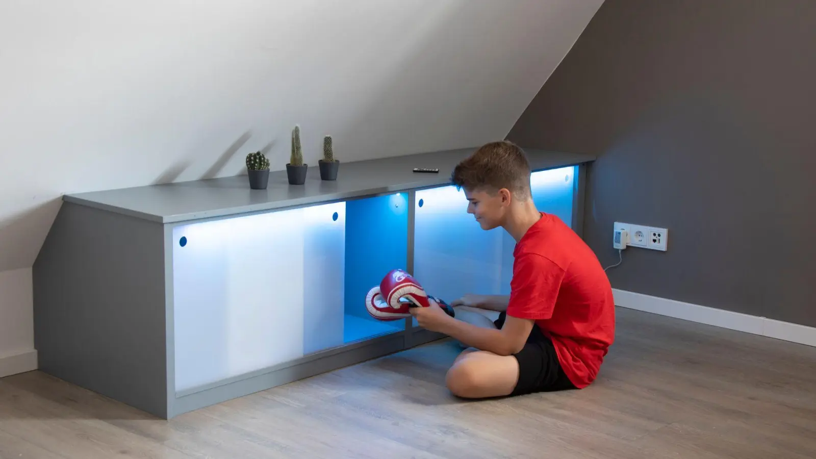 Stauraum unter der Dachschräge: Die Schiebetüren aus Acrylglas werden mit Hilfe eines LED-Bandes von innen indirekt beleuchtet. (Foto: Michael Müller-Münker/Selbst ist der Mann/dpa-tmn)