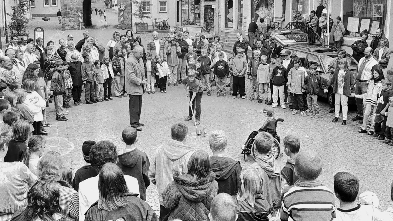 Der Gockeltanz fand vor einem Vierteljahrhundert (die Aufnahme ist aus dem Jahr 2000) noch in der Hauptstraße statt und damit räumlich etwas getrennt von der Kirchweih, die ihren Standort am damaligen Festplatz, dem heutigen Edeka-Parkplatz, hatte. Bei der Wiederaufnahme des Brauchs im Jahr 1926 tanzten die Kinder auf der anderen Seite des im Hintergrund erkennbaren oberen Tores. (Archivbild: Andreas Reum)