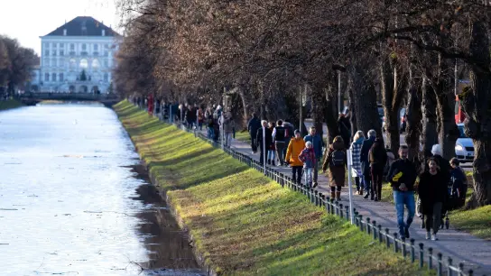 Menschen gehen am Nymphenburger Kanal in München spazieren. (Foto: Sven Hoppe/dpa)