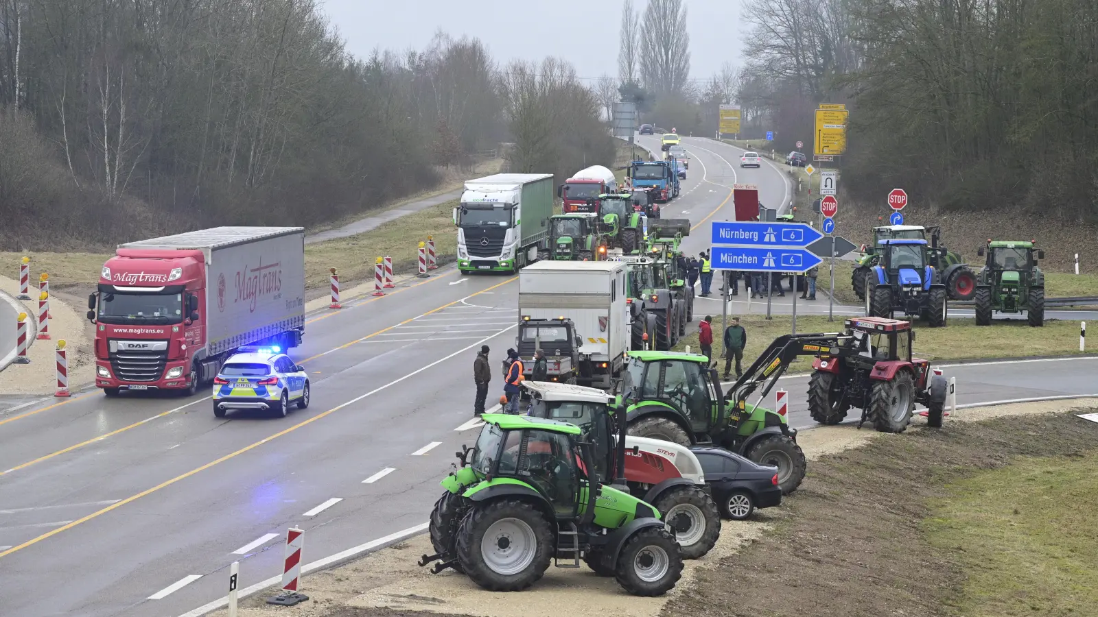 Traktoren auf dem Seitenstreifen und auf der Fahrbahn, dazu Blaulicht: Während der Proteste der Landwirte brauchen Lkw- und Autofahrer Geduld. (Foto: Jim Albright)