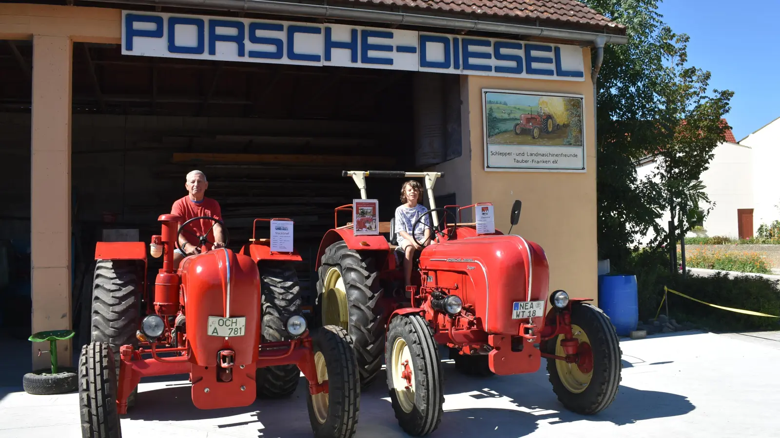 Ewald Haag ist leidenschaftlicher Sammler alter Traktoren. Vor allem die roten Exemplare von Porsche haben es ihm angetan. Fürs Foto setzte sich sein Enkel Noah hinters Steuer – bis der Zehnjährige fahren darf, dauert es aber noch ein paar Jahre. (Foto: Ute Niephaus)