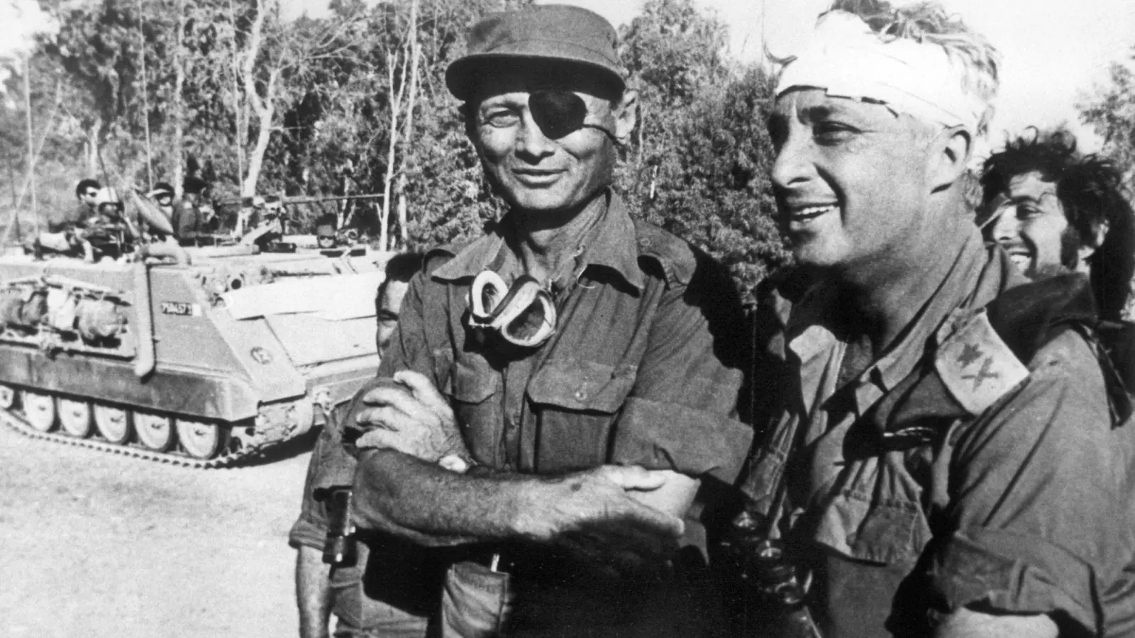 Der damalige israelische Verteidigungsminister und General Mosche Dajan (l.) mit dem damaligen Generalmajor Ariel Scharon, der einen Kopfverband trägt, aufgenommen im Oktober 1973 auf der ägyptischen Seite des Suezkanals während des 4. israelisch-arabischen Krieges. (Foto: UPI/dpa)