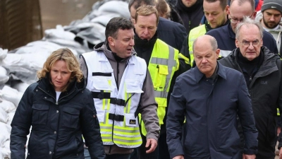 Bundeskanzler Olaf Scholz (vorne rechts) trägt bei seinem Besuch im Hochwassergebiet in Sangerhausen Gummistiefel. (Foto: Jan Woitas/dpa)