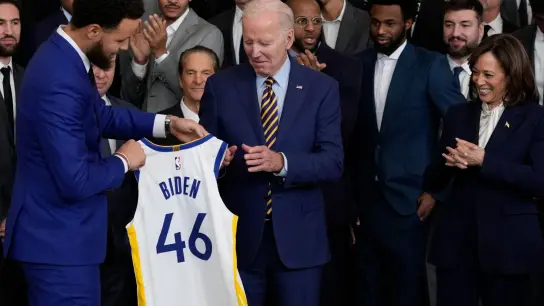 Warriors-Superstar Stephen Curry (l) überreicht Joe Biden ein Trikot. (Foto: Susan Walsh/AP/dpa)