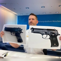 Polizeisprecher Thomas Schelshorn zeigt Fotos der Softair-Waffe und der echten Waffe.  (Foto: Sabine Dobel/dpa)