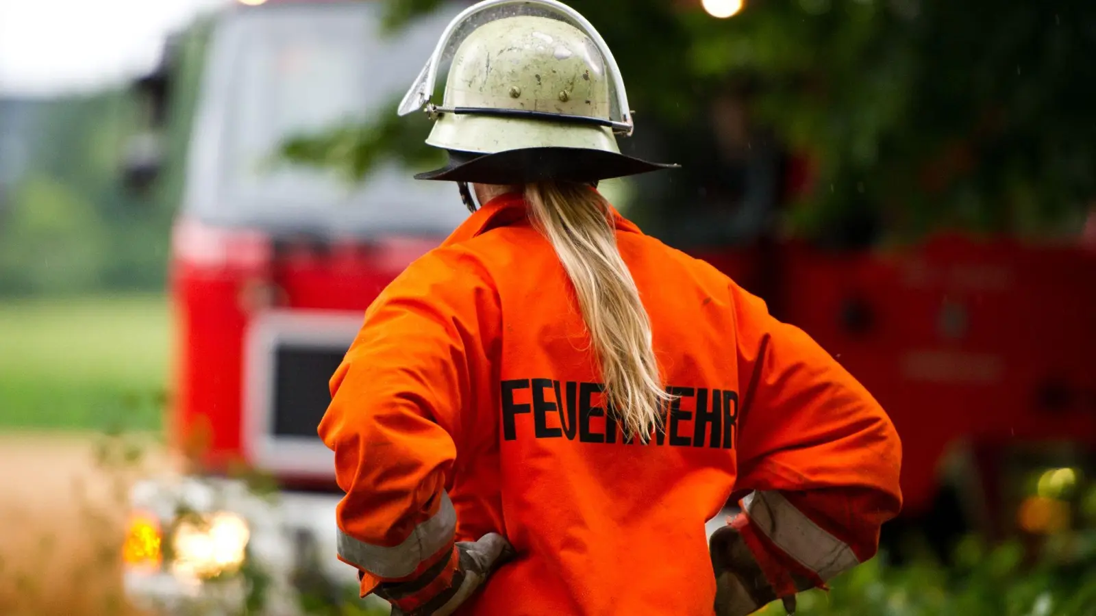 Eine Feuerwehrfrau steht an einer Einsatzstelle. (Foto: Daniel Bockwoldt/dpa)
