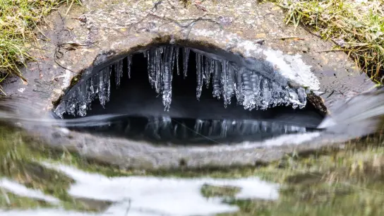Wie ein Portal in die Unterwelt präsentiert sich ein Wassereinlauf mit kleinen Eiszapfen in Brandenburg. Es scheint fast so, als könnte man hier mit einem Boot zu einem fantastischen Abenteuer aufbrechen. (Foto: Frank Hammerschmidt/dpa)