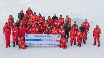Forscher des Alfred Wegener Instituts mit einem Transparent mit der Aufschrift „#Scientists4Future - We deliver the facts. It&#39;s time to act” in der Arktis. (Foto: Esther Horvath/Alfred Wegener Institut/dpa)