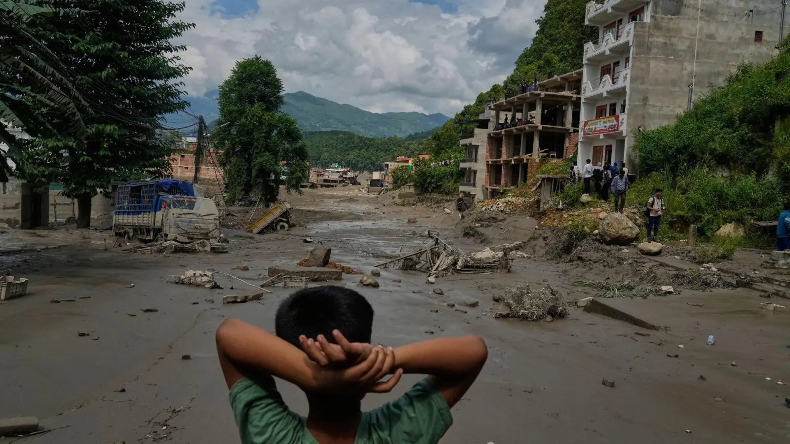 Ein Junge betrachtet die Verwüstungen, die durch Sturzfluten am Fluss Trishuli im nepalesischen Distrikt Nuwakot verursacht wurden. (Archivbild) (Foto: Niranjan Shrestha/AP/dpa)