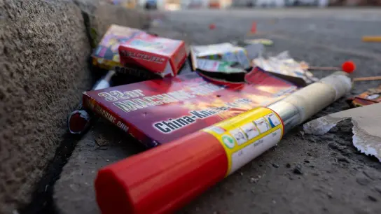 Verpackungen und abgebrannte Feuerwerkskörper liegen auf einer Straße. (Foto: Sven Hoppe/dpa)