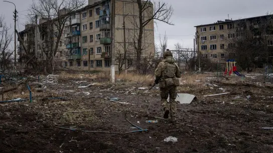 Ein ukrainischer Marinesoldat geht in Wuhledar an zerstörten Wohnblocks vorbei. (Foto: Evgeniy Maloletka/AP/dpa)