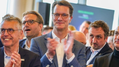 Ministerpräsident Hendrik Wüst (M) freut sich über 1,4 Millionen Teilnehmer am Olympia-Votum.  (Foto: Christoph Reichwein/dpa)