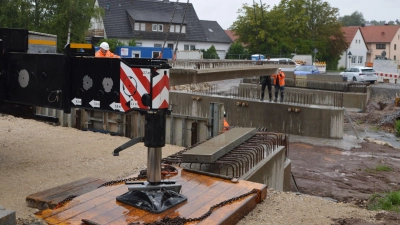 Am Haken: Ein Kran hievte am gestrigen Dienstagmorgen bei strömendem Regen Fertigteile auf die Steinachbrücken-Baustelle in Gutenstetten. (Foto: Johannes Zimmermann)