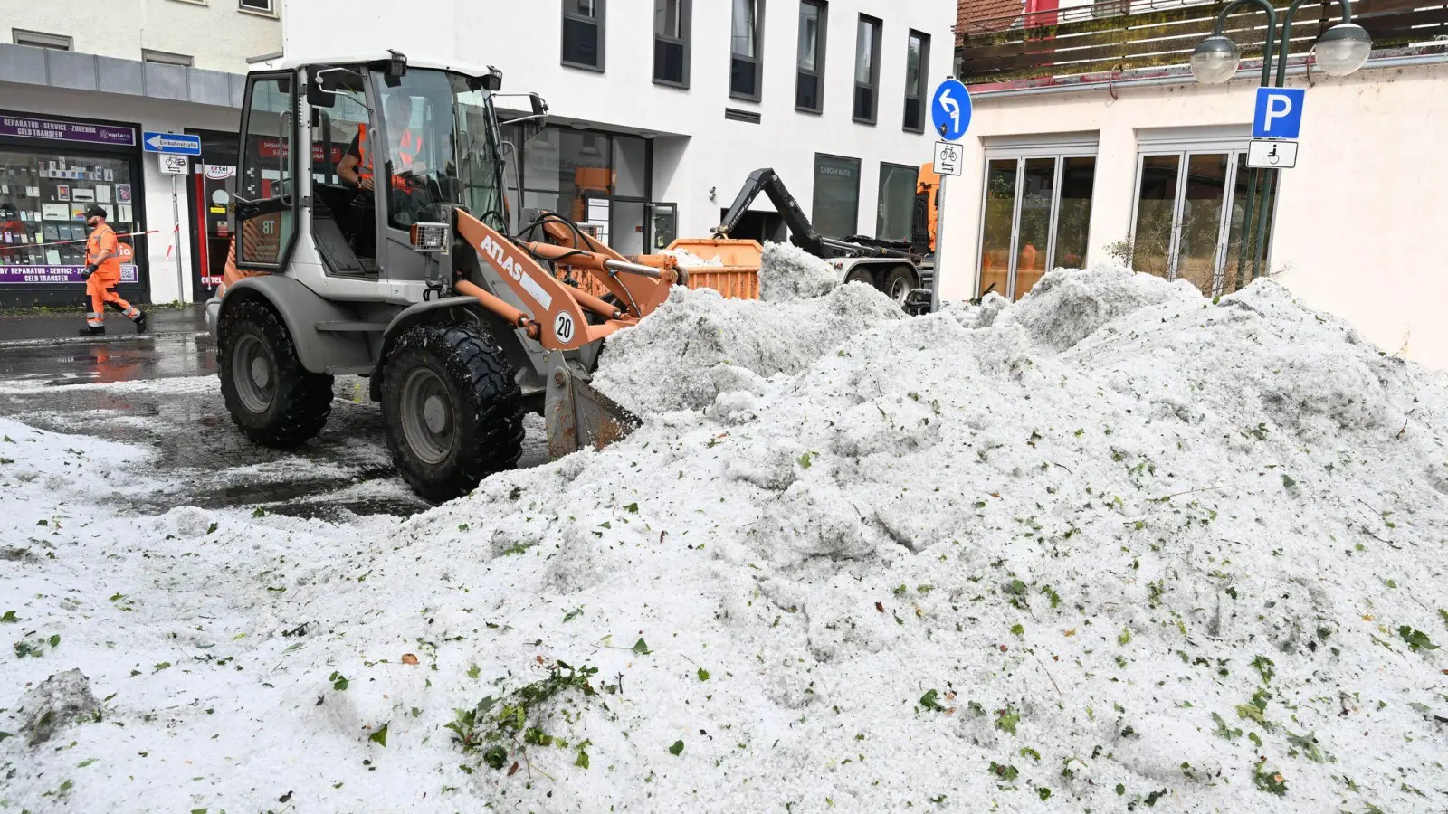 Die Stadtreinigung entfernen Hagel in der Innenstadt. (Foto: Bernd Weißbrod/dpa)