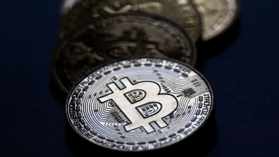 Bitcoin-Münzen liegen auf einem Tisch. (Foto: Hannes P Albert/dpa)
