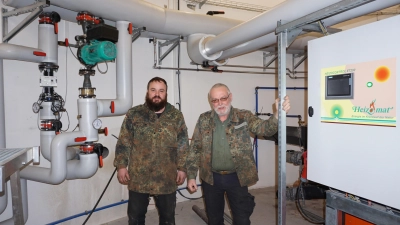 Hans Bayer (rechts) und Sohn Frank wollen ihr Nahwärmenetz erweitern. Ihre Hackschnitzelheizung hat eine Leistung von 400 Kilowatt. (Foto: Andrea Walke)