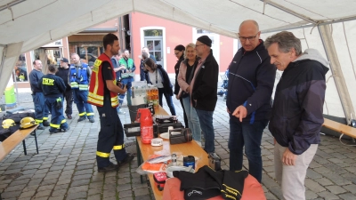 Wie sollten sich die Bürgerinnen und Bürger persönlich auf einen totalen Blackout vorbereiten? Empfehlungen dazu bot das THW-Team am Donnerstagabend in einem Informationszelt auf dem Marktplatz an. Näheres dazu erklärte Zugführer Christopher Beckler (vorne links) den Interessierten. (Foto: Peter Zumach)