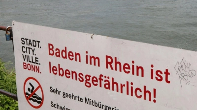 Mit einem Hinweisschild „Baden im Rhein ist lebensgefährlich“ warnt die Stadt Bonn die Menschen vor den Gefahren beim Schwimmen im Rhein. (Foto: Roland Weihrauch/dpa)
