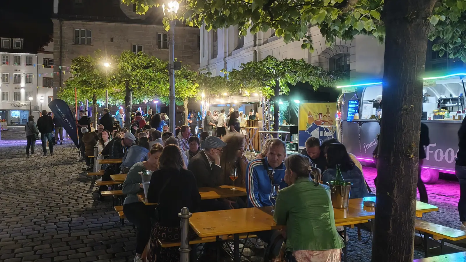 Die Tische des Weindorfs am Johann-Sebastian-Bach-Platz waren laut dem Verantwortlichen Florian Lacher „super gut gefüllt”. Am Samstagabend verweilten einige Gäste bei lauen Temperaturen auch bis in die Dunkelheit. (Foto: Robert Maurer)