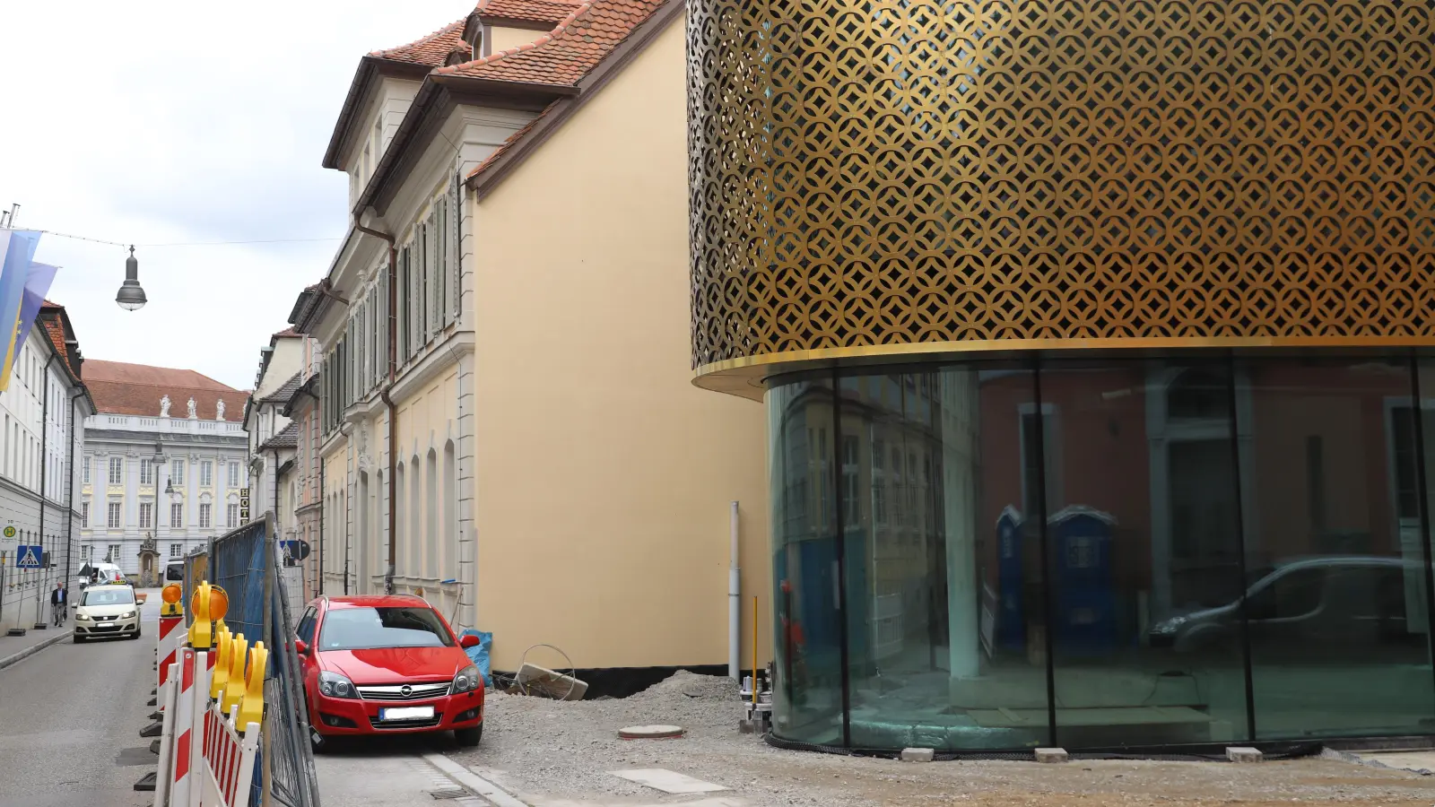 Noch ragt am Retti-Palais der Bauzaun in die Straße. „In Kürze“ soll er zurückrücken. (Foto: Oliver Herbst)