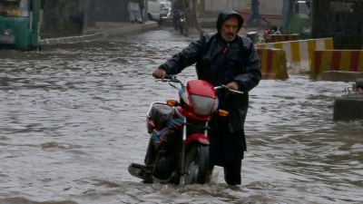 Starke Regenfälle haben die Straßen im pakistanischen Peschawar überschwemmt. In Pakistan sind bei für diese Jahreszeit ungewöhnlich starken Regenfällen mehrere Menschen ums Leben gekommen. (Foto: Muhammad Sajjad/AP/dpa)