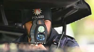 Ein Polizist kontrolliert mit einem Messgerät die Geschwindigkeit von Fahrzeugen in einer 30er-Zone. Die Polizei in Hamburg nimmt seit Montag Geschwindigkeitssünder bei der sogenannten Speedweek ins Visier. (Foto: Jonas Walzberg/dpa)