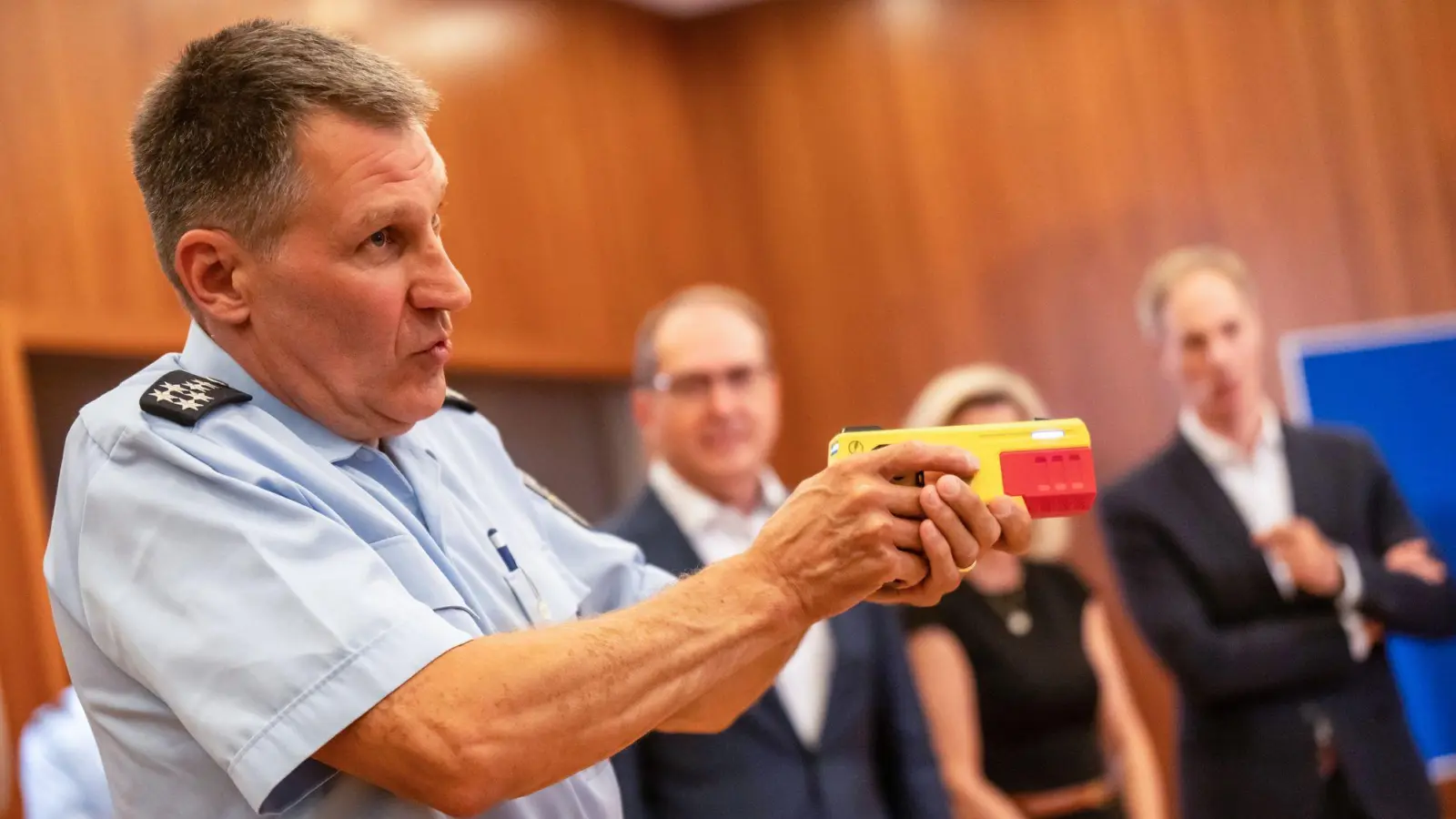 Ein Polizist erklärte die Funktionsweise eines Distanz-Elektroimpulsgeräts im vergangenen Jahr im Innnenministerium. (Archivfoto) (Foto: Michael Kappeler/dpa)